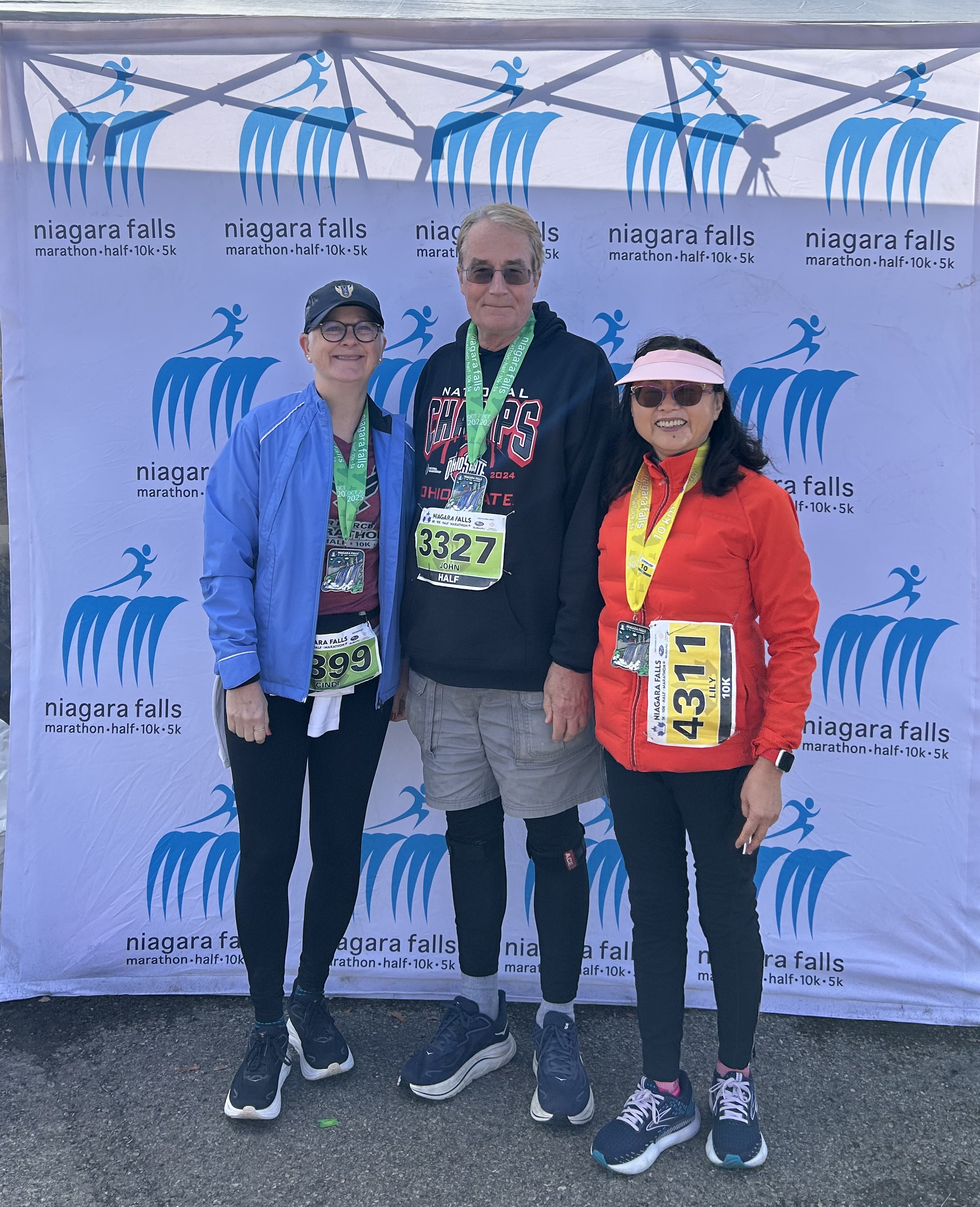three people wearing race medals who finished the Niagara Falls International Half Marathon