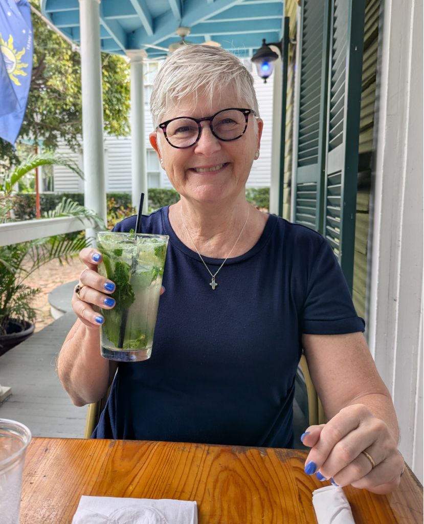 woman in blue dress enjoying an after-race mojito in Key West
